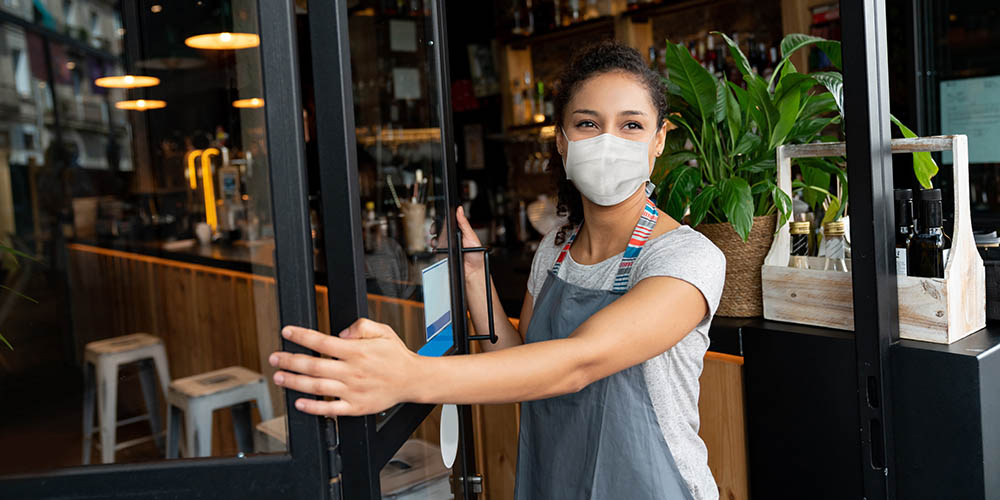 bar employee smiling at the open door to the front of the bar